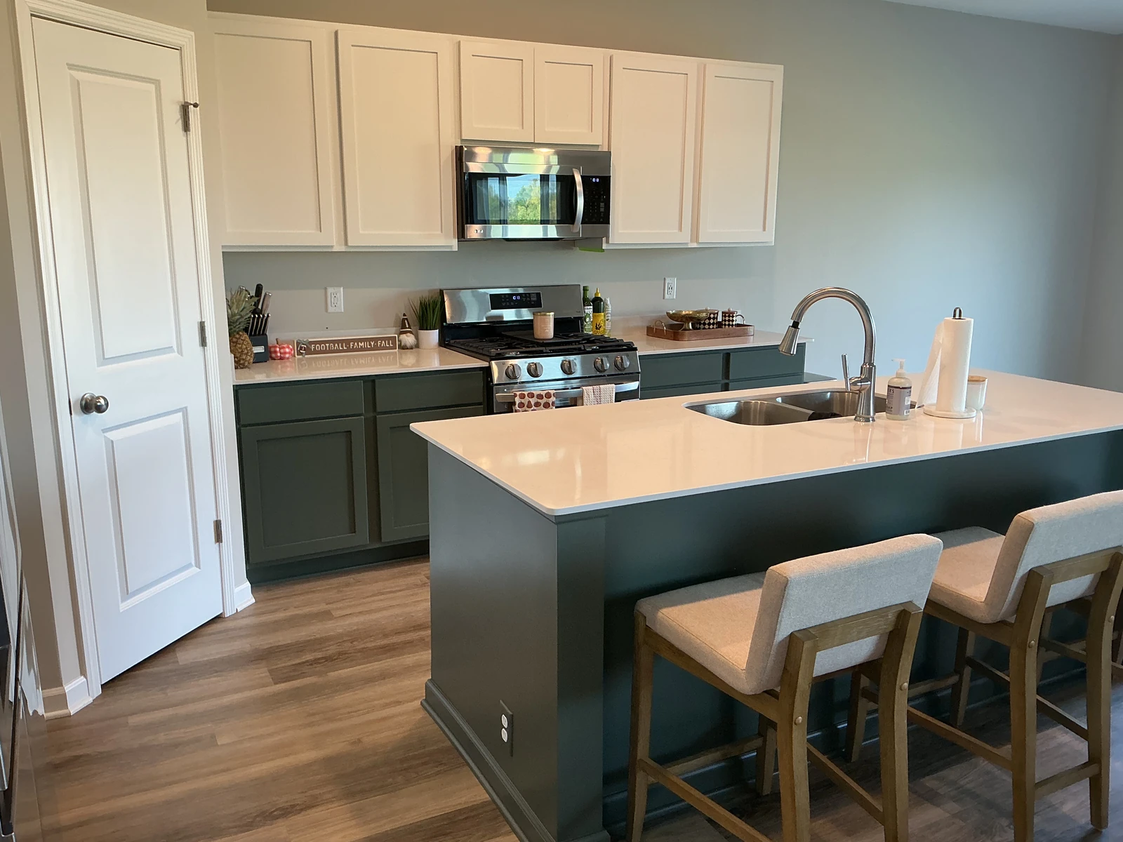 Refinished Pewter Green kitchen island and base cabinets viewed from the seating area.